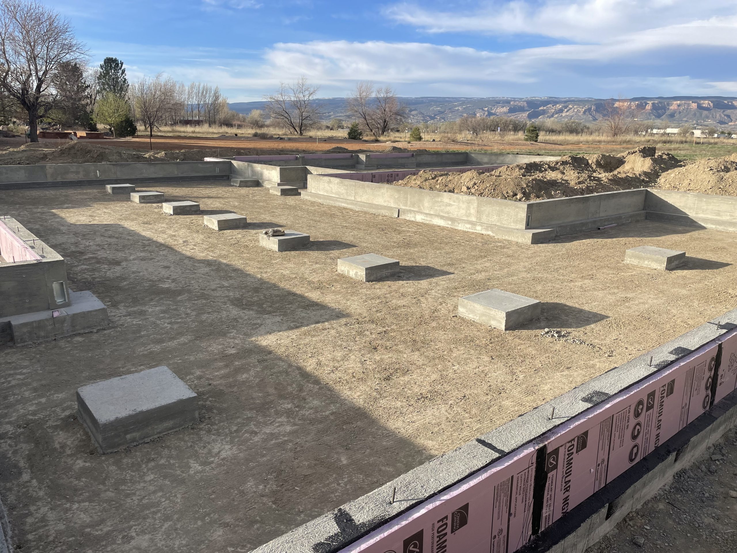Archaeological site with stone foundations under a blue sky.